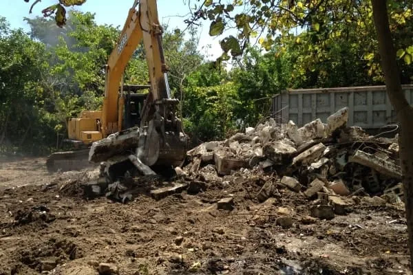 Heavy equipment crane handling large commercial junk removal job in South Florida